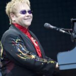 Elton John cantando ao piano em show, referência ao show do Rock in Rio 2026